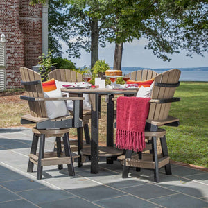 Tan and black poly round bar height patio set for four with swivel chairs, throw and cake by a lawn and bay