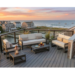 Poly patio sofa, loveseat, chair and tables with cream cushions on an oceanfront deck at sunset