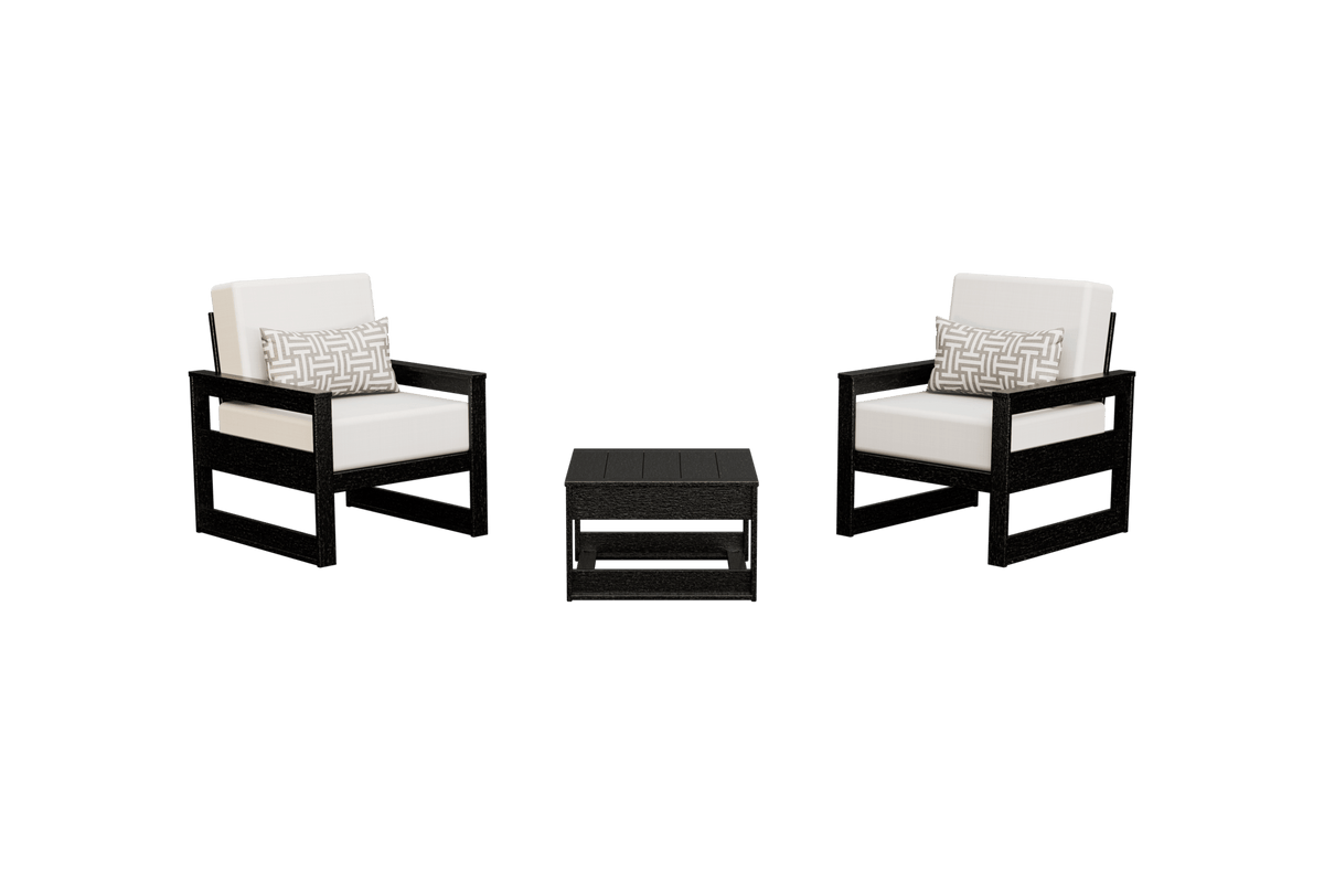 Two black poly patio club chairs with white cushions and geometric pillows flanking a square side table