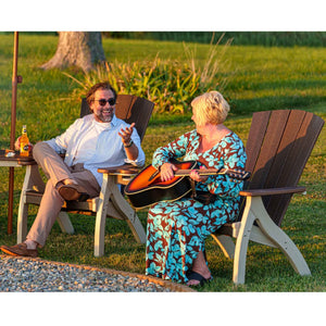 Couple relaxing in brown and weatherwood poly siesta chairs on a lawn at sunset, one playing an acoustic guitar