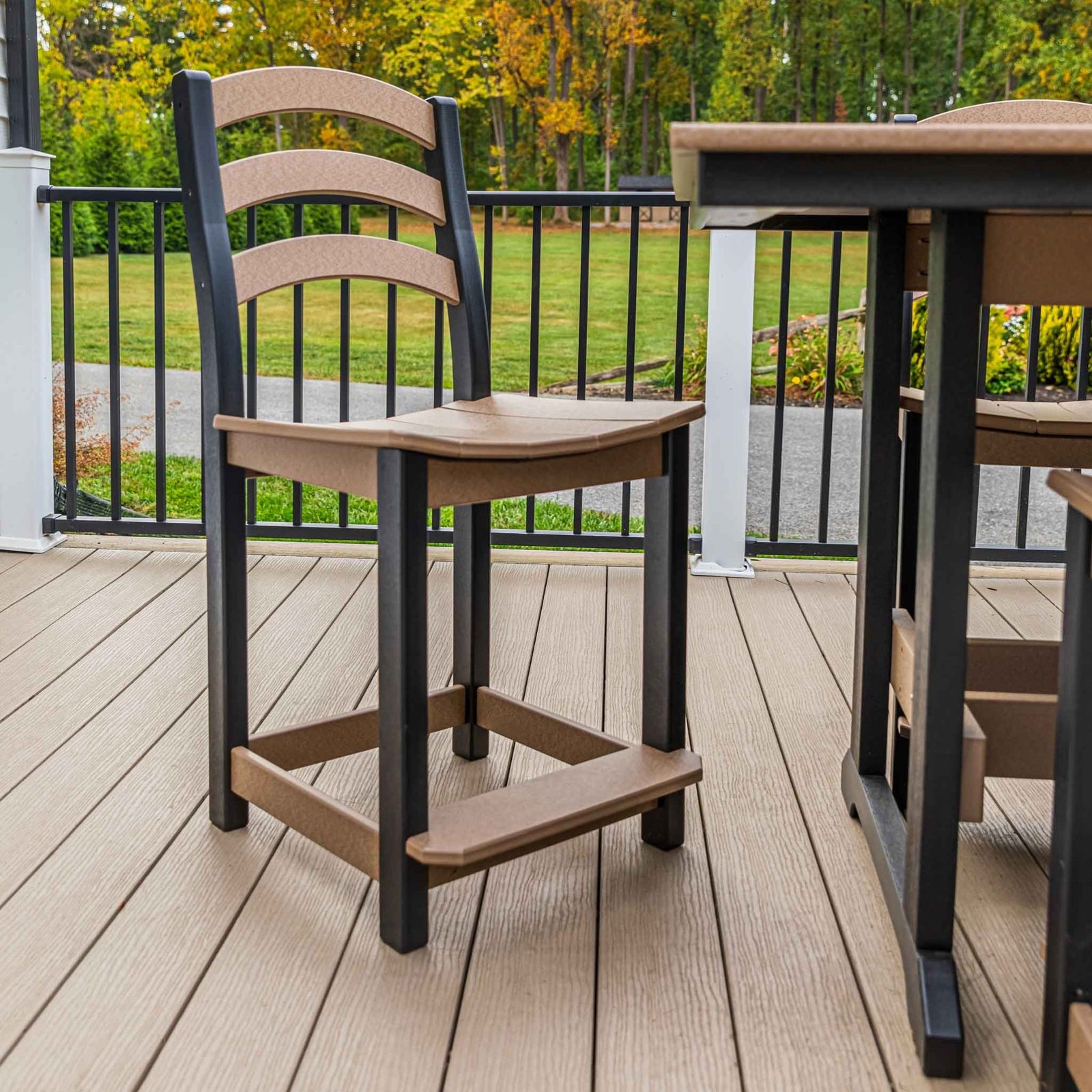 Cedar brown and black ladder back counter chair on a composite deck beside a matching pub table