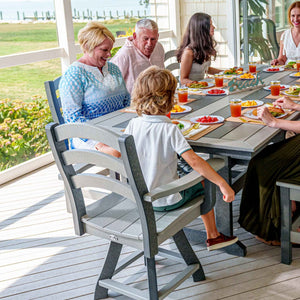 Family eating breakfast at a gray poly patio dining table with ladder back chairs on a screened porch