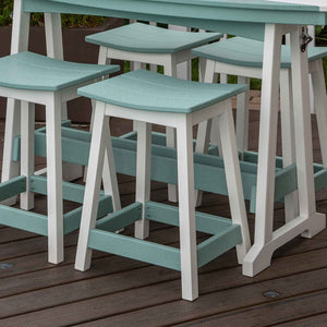 Aquamarine and white poly saddle bar stools with curved seats and footrest rails on a brown deck beside a bar table