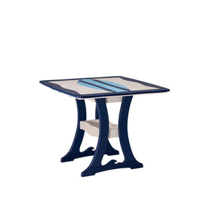 Angled view of a navy and sand poly dining table with light blue surfboard inlay, curved legs and shelf on white