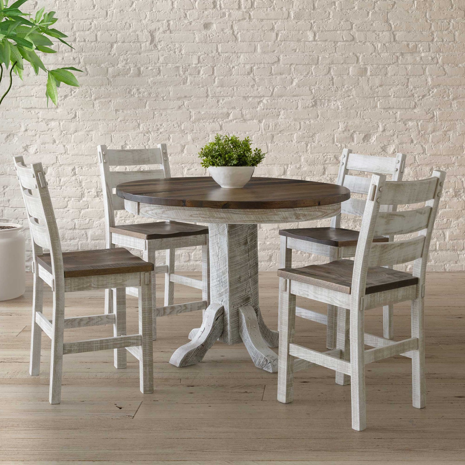 Round counter height table with a dark stained top, whitewashed pedestal base and four ladder back stools