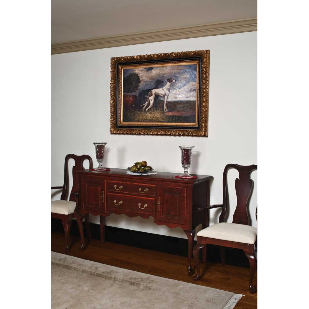 Deep cherry Queen Anne sideboard with brass bail pulls and scalloped apron flanked by two upholstered arm chairs