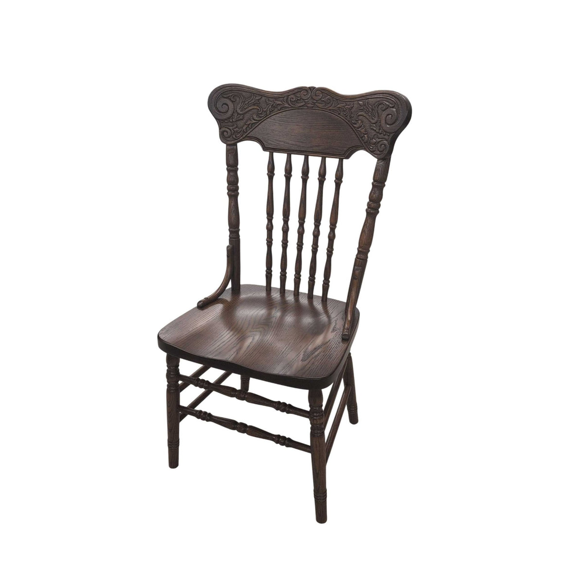 Dark walnut stained pressback chair with a carved scroll crest rail, turned spindles and shaped saddle seat