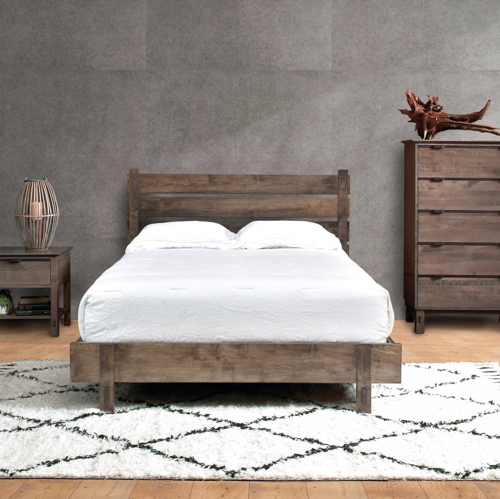 Rustic plank bed with slatted headboard and exposed peg joinery in a gray loft with nightstand and tall chest