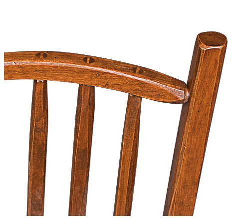 Close view of a cherry stool crest rail joined to the back post with visible peg detailing above flat slats
