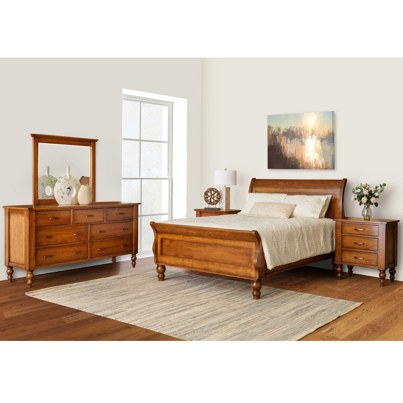 Cherry sleigh bedroom set styled with dresser and mirror, two nightstands and a rug in a bright room