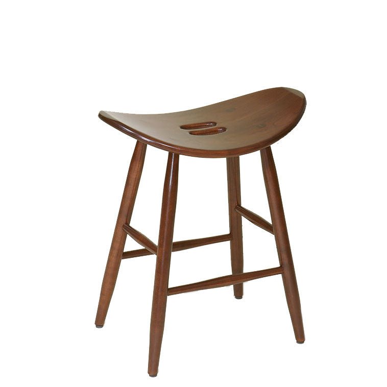 Walnut finished saddle stool with a contoured backless seat, carved hand grip slots and splayed round legs on a white background