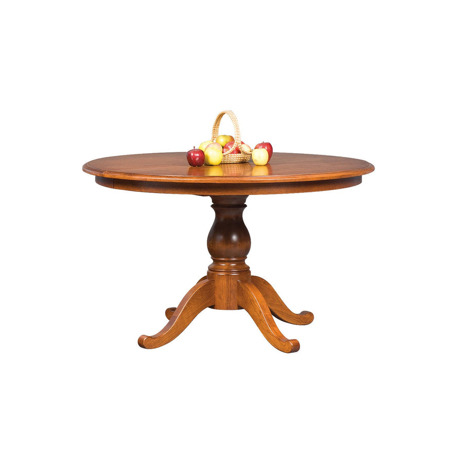 Round oak single pedestal dining table with turned column, four curved scroll feet and a basket of apples on the polished top