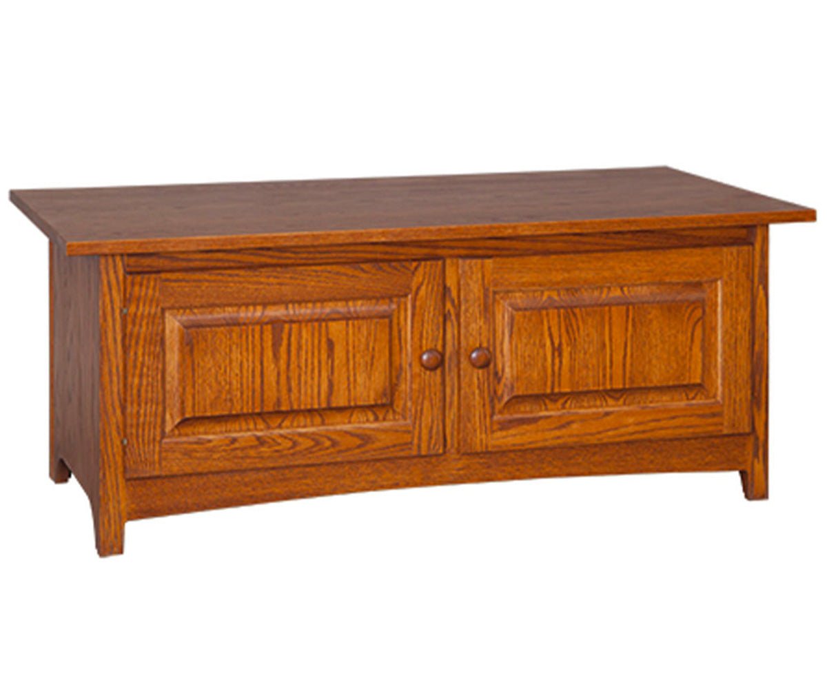 Oak Shaker coffee table with two raised panel doors, round wood knobs and a curved apron on a white background