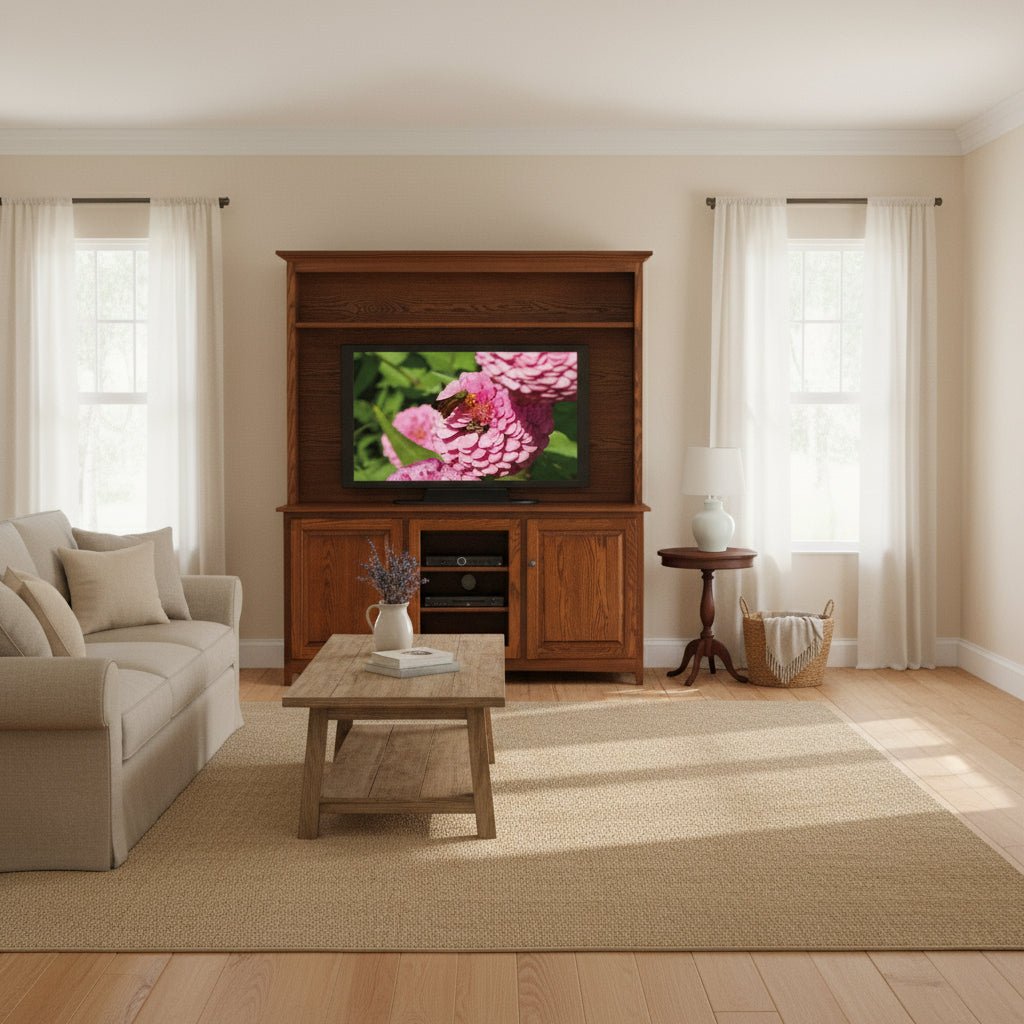 Oak TV stand with hutch holding a large TV, open display shelf above and paneled doors flanking media components