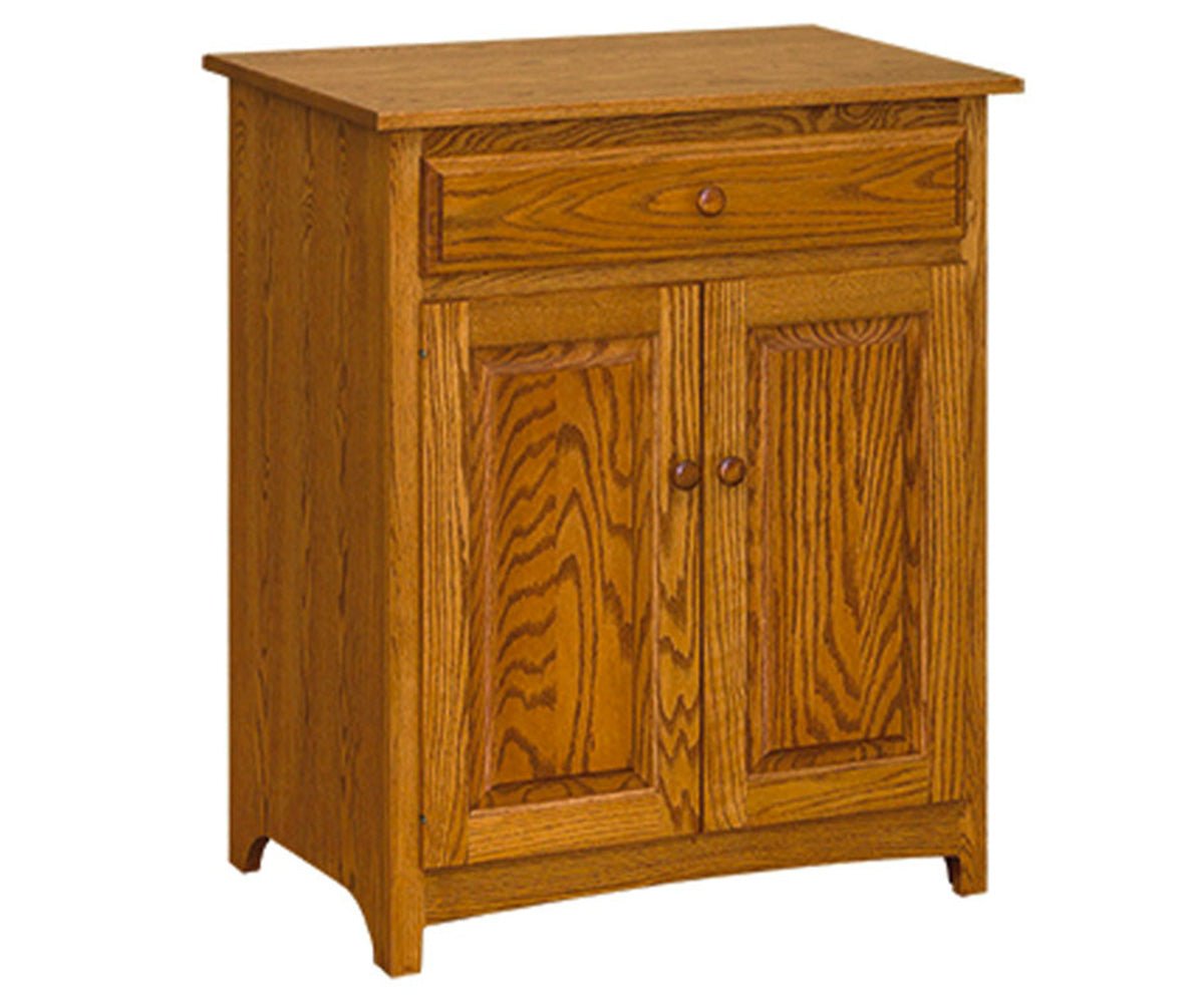 Oak Shaker microwave stand with a wide top drawer and two raised panel doors with wood knobs on a white background