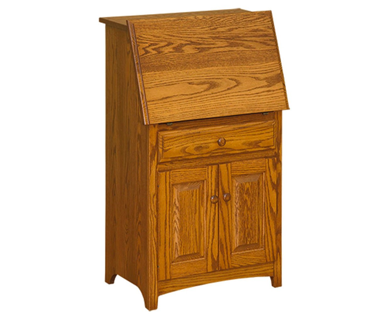 Closed oak mini secretary desk with a slanted lid, one drawer and two raised panel cabinet doors on a white background
