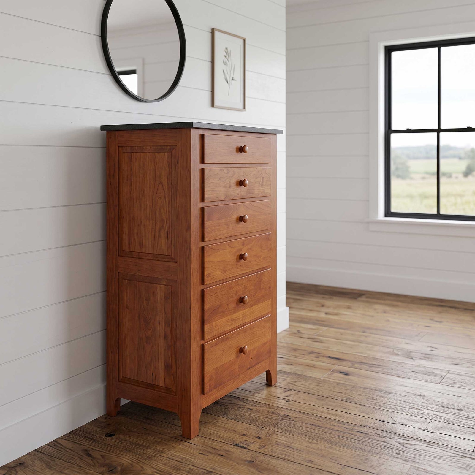 A tall wooden chest of drawers with six drawers and a dark top surface, placed in a bright room with white shiplap walls, a wood floor, a round mirror, and a window.