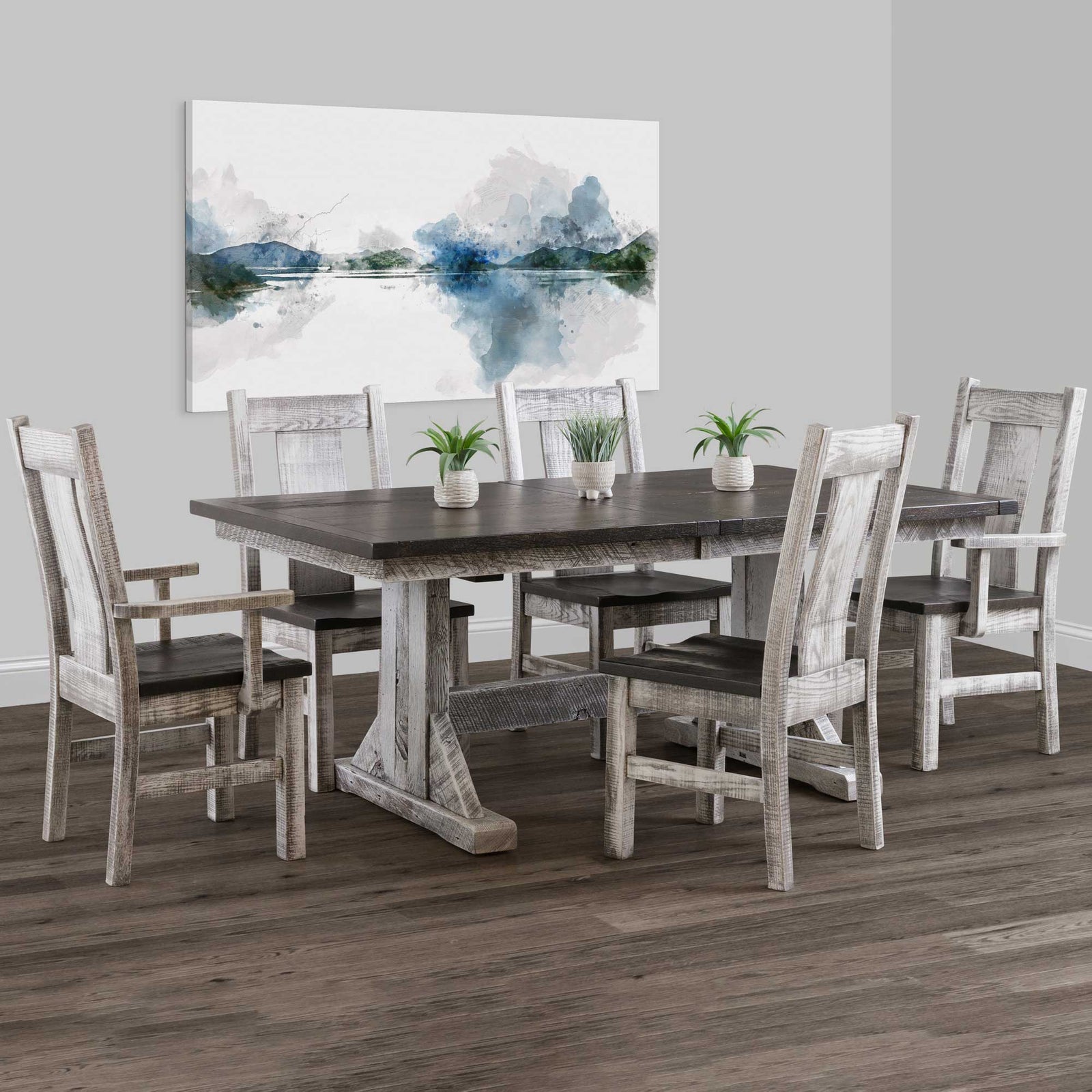 Weathered gray trestle dining table with a dark plank top and six matching slat back chairs including two arm chairs