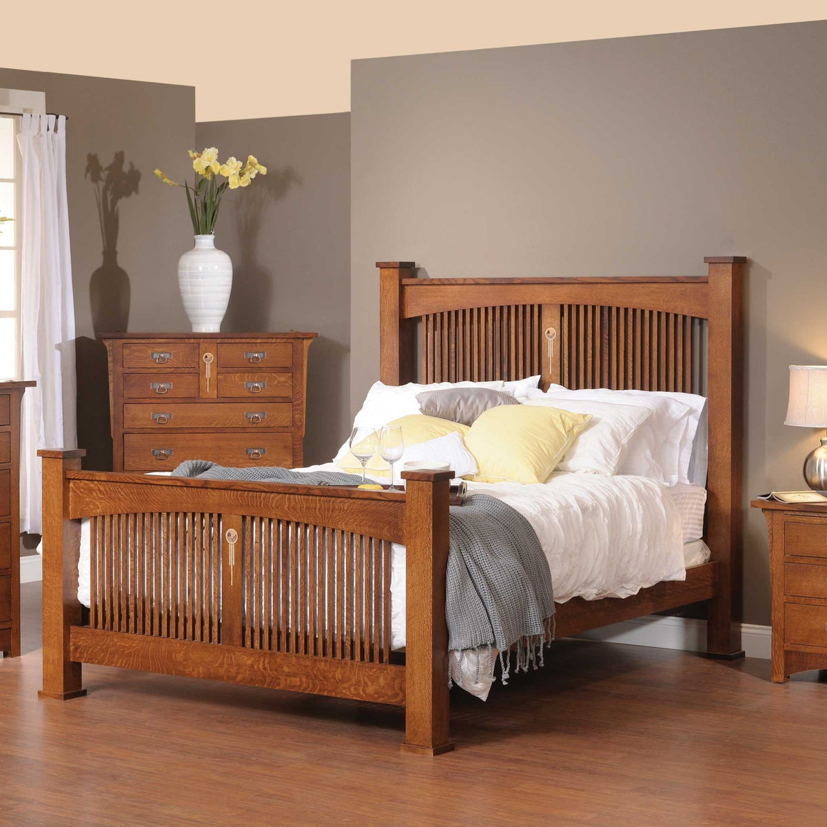 Arched spindle bed in quartersawn oak with slatted headboard and footboard, inlay accents and square posts, styled in a bedroom