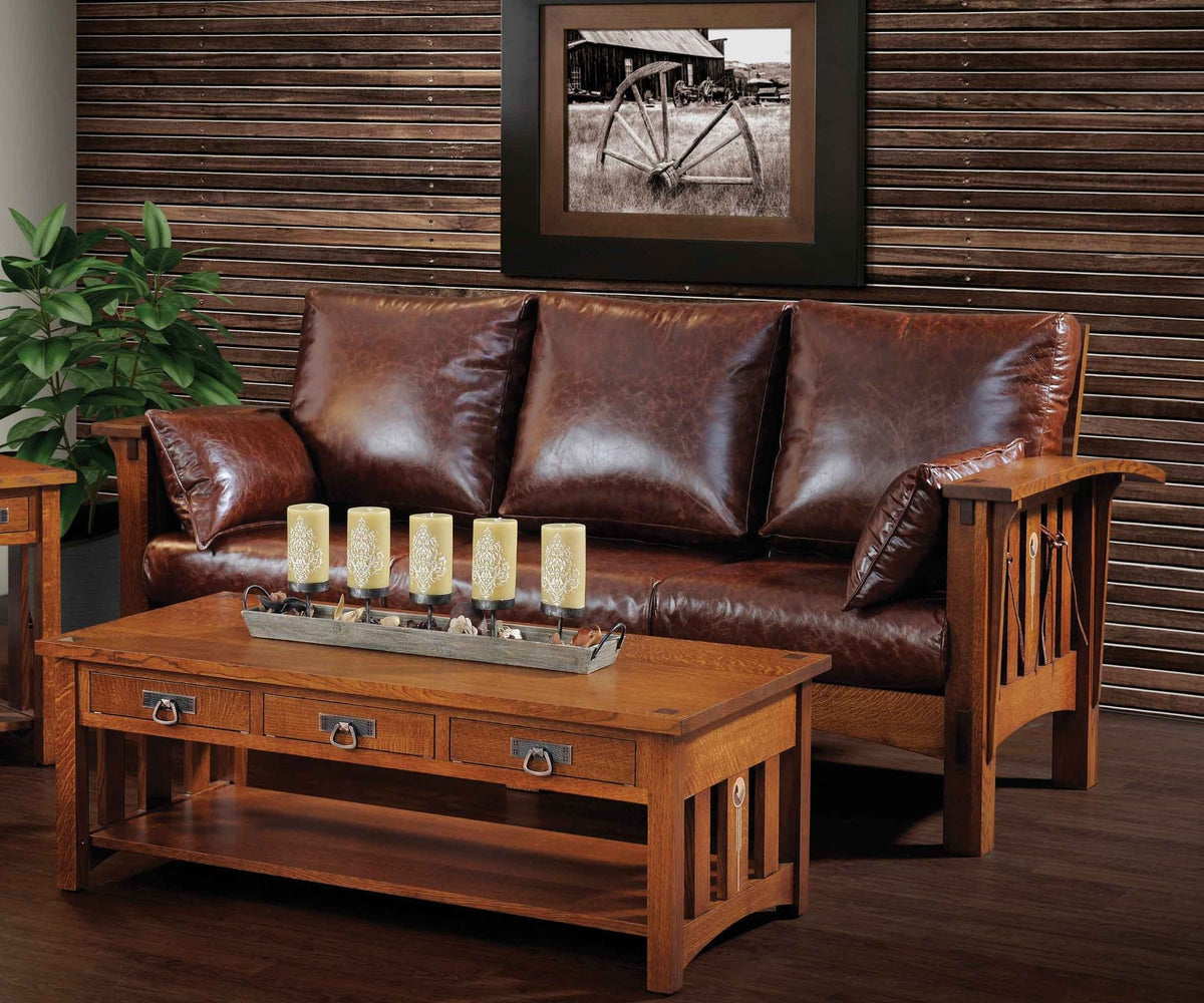 Leather sofa with oak slat arms styled against a wood slat wall with a coffee table and candle tray