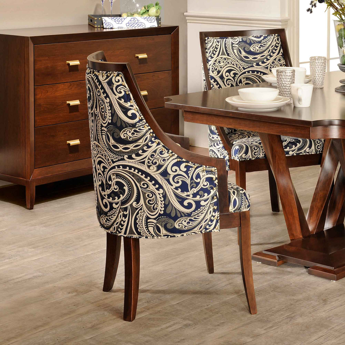 Park Ave cushion dining chair with a curved wood frame and blue and cream paisley upholstery beside a trestle dining table