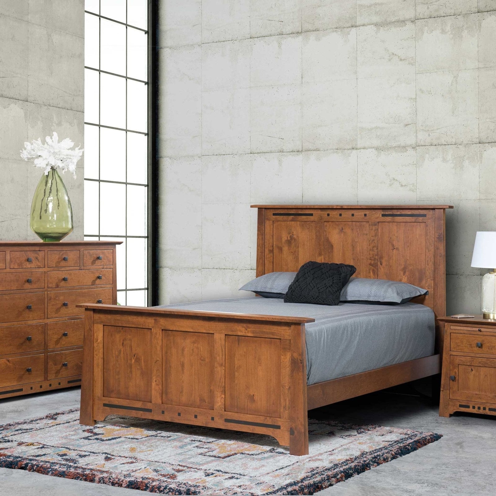 Van Nuys panel bedroom set in cherry with a queen panel bed, twelve-drawer dresser and door nightstand in a loft-style room