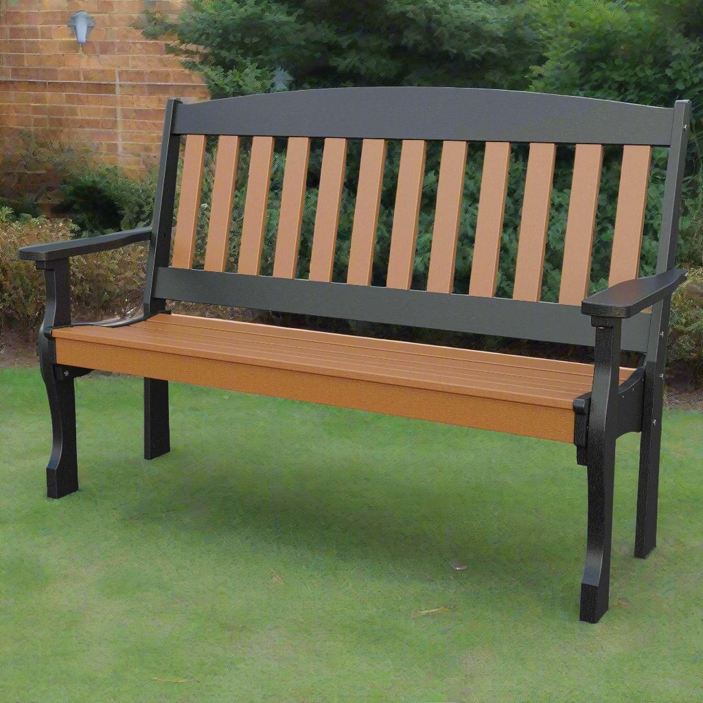 Cedar and black poly patio bench with arched back, slatted seat and wide arms set on green lawn beside a brick wall