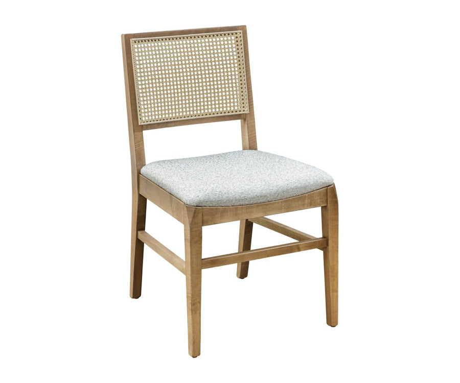 Cane back dining chair with a gray cushioned seat shown beside a light wood trestle dining table on a faded patterned rug
