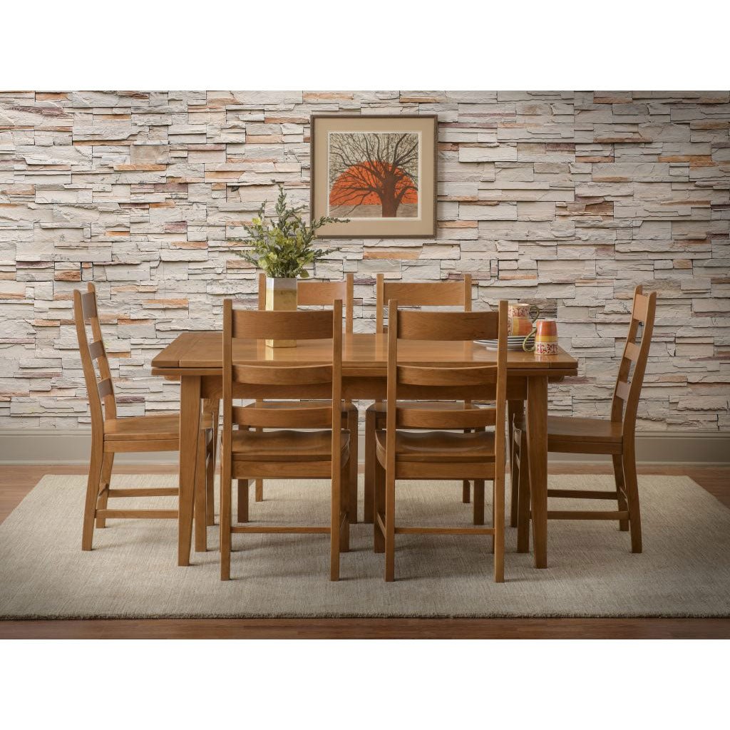 Oak draw leaf dining table with six slat back chairs and wood seats in front of a stacked stone wall
