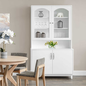 White painted dining hutch with arched glass display doors, lighted shelves and lower storage cabinet beside a round table