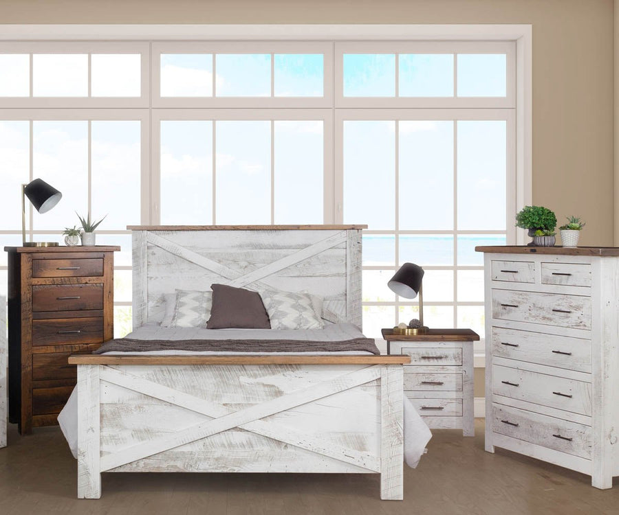 Whitewashed coastal bedroom with an X-panel bed, two nightstands and a chest of drawers before ocean view windows