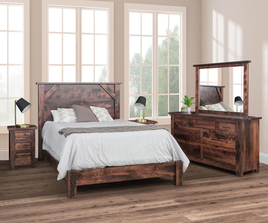 Distressed brown bedroom set with a panel bed, nightstands and a seven-drawer dresser topped by a wide mirror