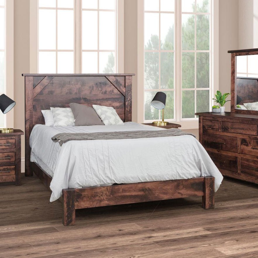 Rustic panel bed with a tall plank headboard and angled corner detail, styled with nightstands and a dresser mirror