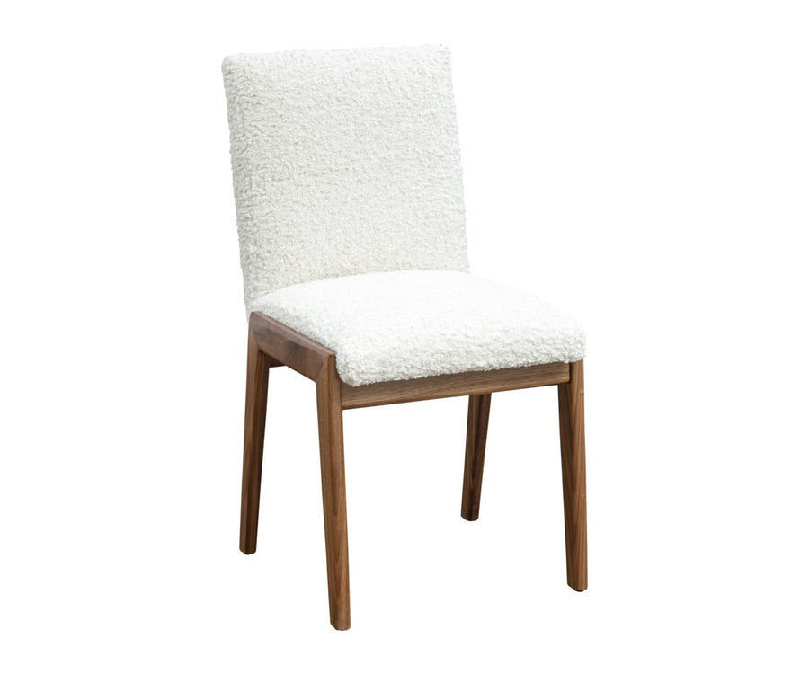 Dining chair upholstered in ivory boucle with a squared padded back and seat on a walnut frame with tapered legs