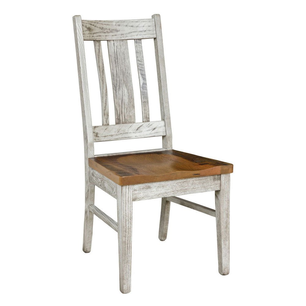 Whitewashed trestle dining table with a warm reclaimed wood top and six matching slat back chairs in a bright brick walled room