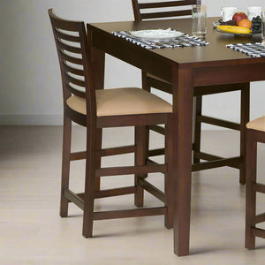Espresso counter height bar chair with a horizontal ladder back and tan upholstered seat at a matching pub table
