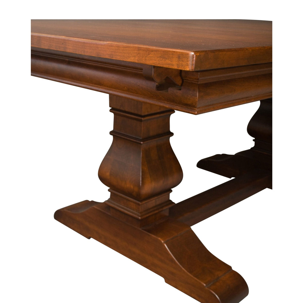 Close view of the carved urn pedestal, molded apron and shaped trestle foot on a cherry dining table