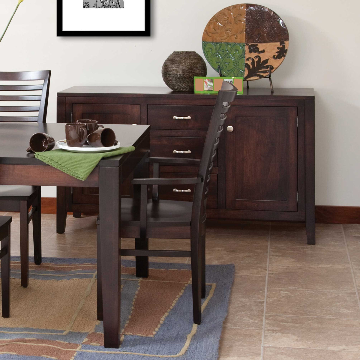 Espresso dining buffet with paneled doors and center drawers, styled with pottery, beside a matching dark dining table