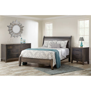 Weathered gray bedroom set with a sleigh bed, six drawer dresser and nightstand, styled with a floral quilt and sunburst mirror