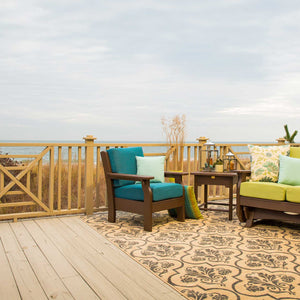 Mahogany poly patio chair with teal deep seating cushions on an oceanfront deck beside a green cushioned glider