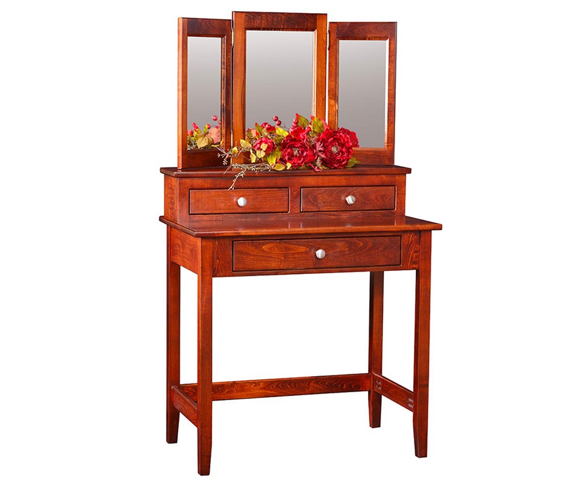 Cherry vanity table with three drawers and a tri-fold mirror, styled by a window in a beamed country bedroom