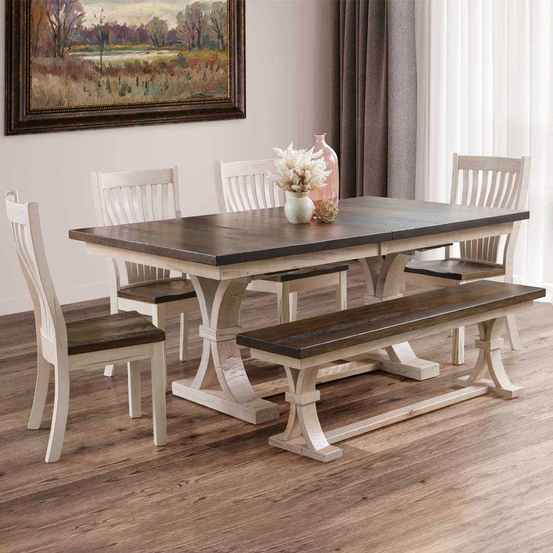 Curved trestle dining set with a dark brown top, antique white base, four slat back chairs and matching bench
