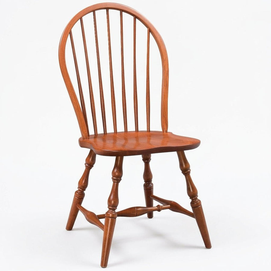 A classic wooden spindleback chair with a warm reddish-brown finish, shown from a three-quarter angle against a plain white background.