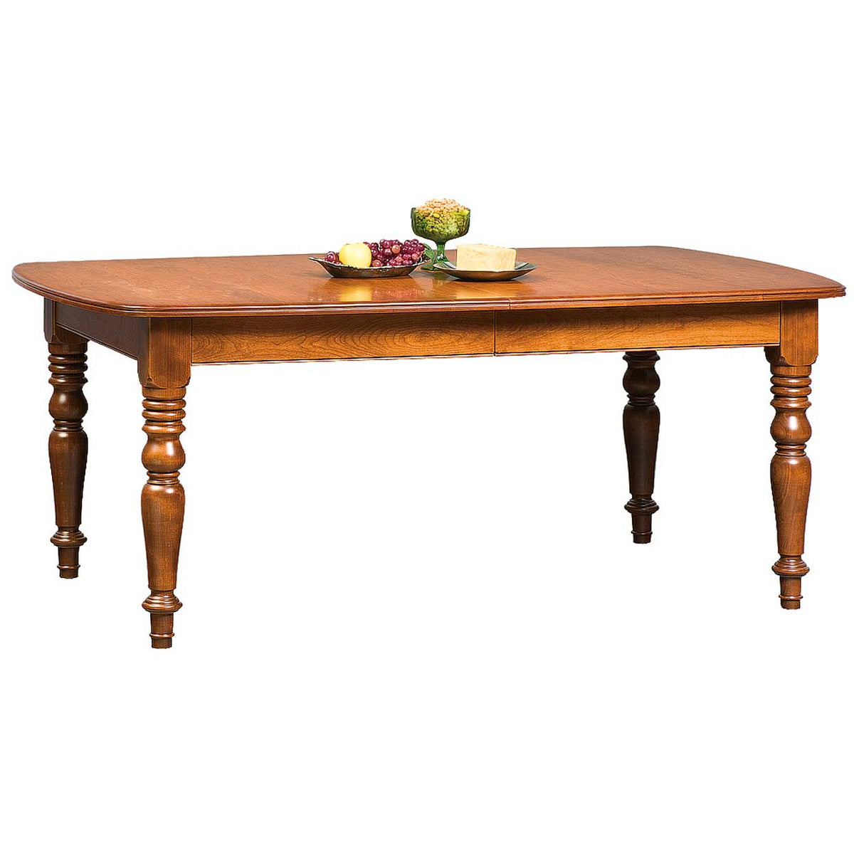 Extended cherry leg dining table with turned legs, styled with a plate of grapes and a bowl of pickles
