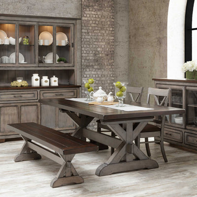Two-tone trestle table and bench set with cross back chairs, china cabinet and buffet in an industrial loft