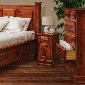 Cherry bedroom vignette with a one drawer nightstand, open chest of drawers and raised panel bed