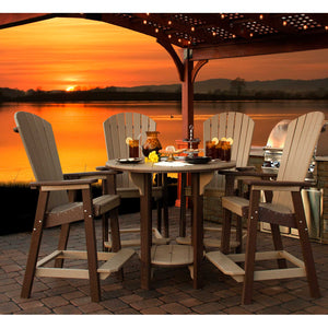 Weatherwood and brown poly round bar table with four fan back Adirondack bar chairs on a paver patio at sunset