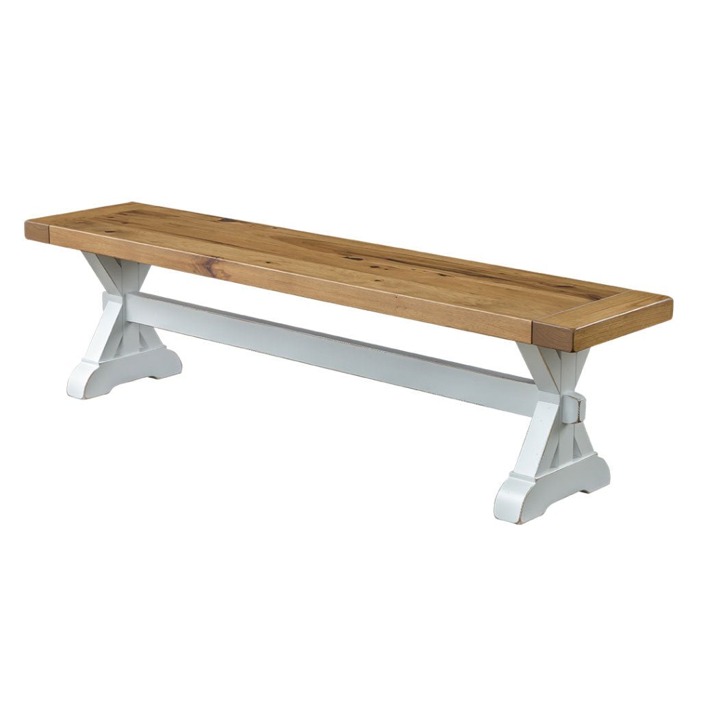 Trestle dining bench with a knotty oak plank seat and bright white X base with center stretcher