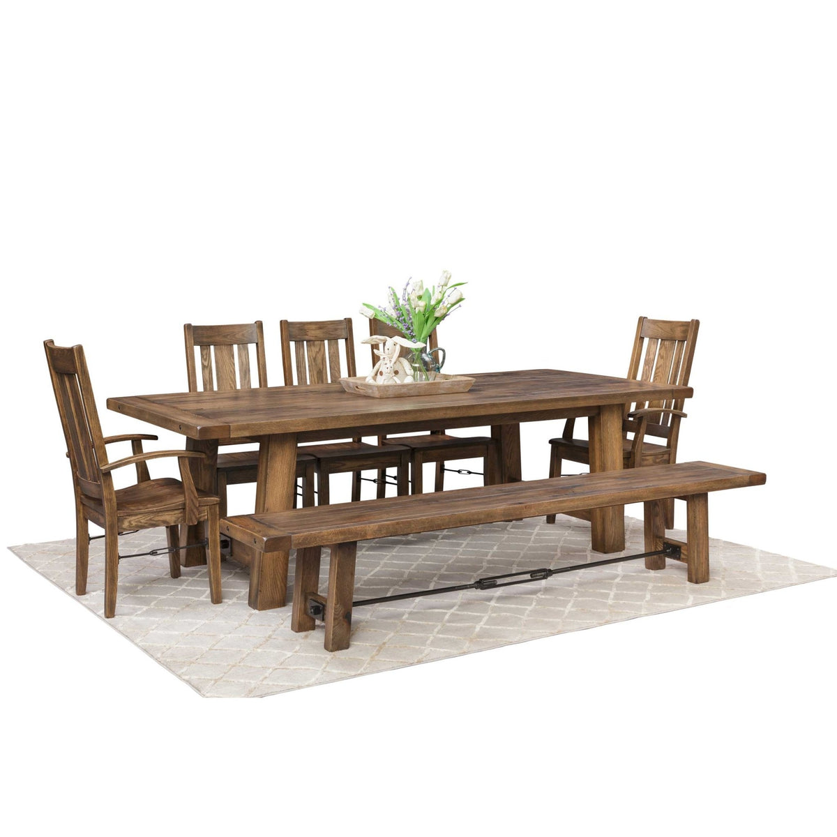 Warm brown Ouray trestle dining set with plank top table, four slat back chairs, arm chair and long bench on a rug