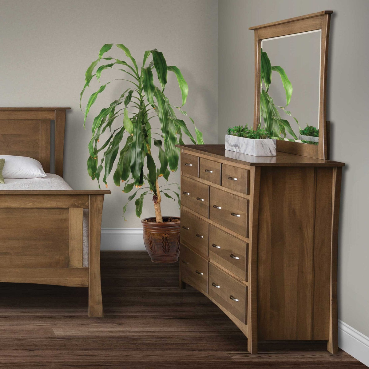 Warm brown nine drawer dresser and mirror with curved sides, styled with a plant beside a panel bed